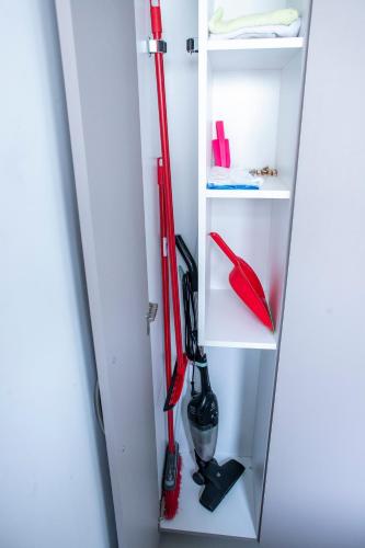a closet with two red hockey sticks on a shelf at B&B Apartamento acolhedor Bem localizado, Próximo ao aeroporto in São José dos Pinhais