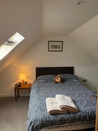 a dog laying on a bed in a bedroom at Palmiro Cottage in Lapford