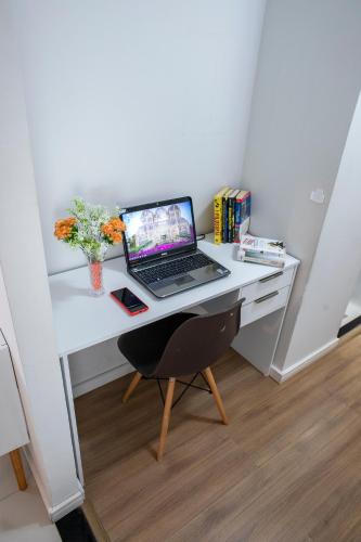 a desk with a laptop computer on top of it at B&B Apartamento acolhedor Bem localizado, Próximo ao aeroporto in São José dos Pinhais