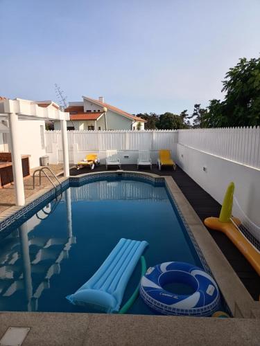 a swimming pool with two lounge chairs in a backyard at Villa Nenúfares in Torreira