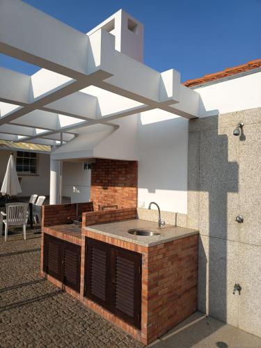 a outdoor kitchen with a sink in a patio at Villa Nenúfares in Torreira