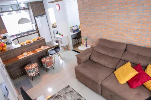 a living room with a couch and a brick wall at B&B Apartamento acolhedor Bem localizado, Próximo ao aeroporto in São José dos Pinhais