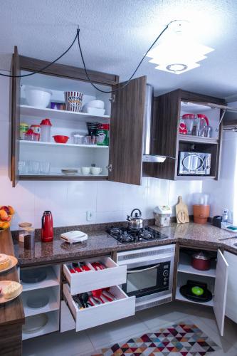 a kitchen with a stove and a counter top at B&B Apartamento acolhedor Bem localizado, Próximo ao aeroporto in São José dos Pinhais