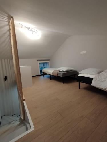 two beds in a room with wooden floors at Maison au calme L'échappée Tarnaise in Cunac