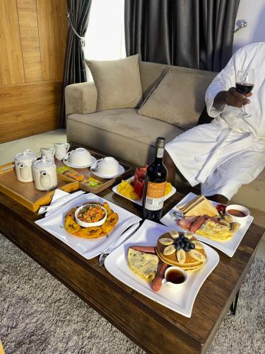a table full of food and wine on a couch at Morgan Hill Residence in Abuja