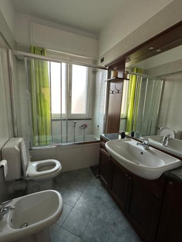 a bathroom with two sinks and a toilet and a mirror at Casa Gioia in Besano