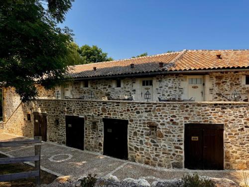 an old stone building with four doors on it at Domaine de Brise Bois - Chambres & Gîtes in Rouzède