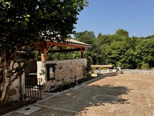 a stone building with a gazebo in a park at Domaine de Brise Bois - Chambres & Gîtes in Rouzède
