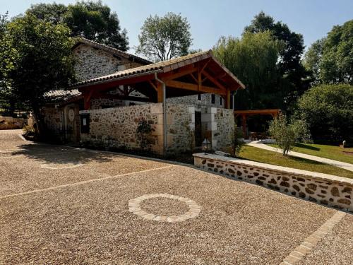 a stone building with a pavilion in front of it at Domaine de Brise Bois - Chambres & Gîtes in Rouzède