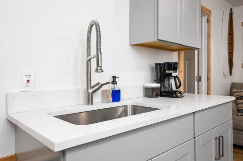 a kitchen with a sink in a white kitchen at Arbutus Lake-King Suite-Pontoon Rentals in Traverse City