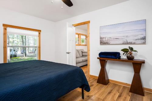 a bedroom with a bed and a table and a window at Arbutus Lake-King Suite-Pontoon Rentals in Traverse City
