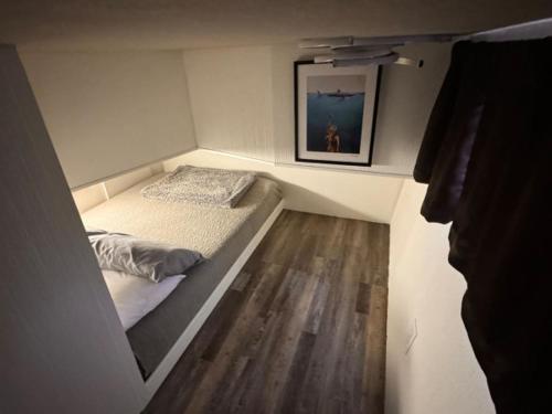 a small bedroom with a bed and a painting on the wall at b3 Couples Therapy Yacht in La Crosse