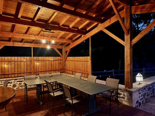 a wooden pavilion with a table and chairs on a deck at Domaine de Brise Bois - Chambres & Gîtes in Rouzède