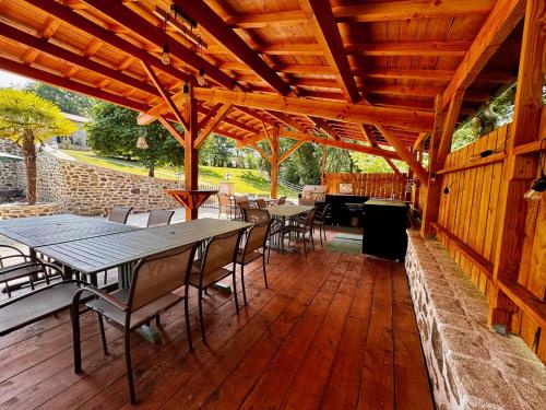 a wooden pavilion with tables and chairs on a deck at Domaine de Brise Bois - Chambres & Gîtes in Rouzède