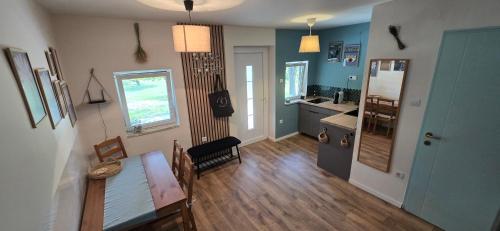 a kitchen with blue walls and a table and a dining room at Lejtőliget Zamárdi in Zamárdi
