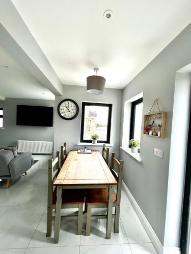 a dining room with a table and a clock on the wall at The Ocean Nest 