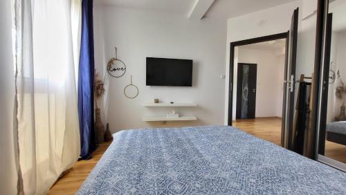 a bedroom with a bed and a tv on a wall at ApartMorze Apartamenty na Leśnej in Jastarnia