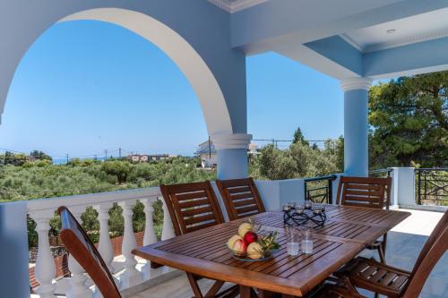 una mesa de madera en un balcón con mesa y sillas en Skyblue Villa, en Akrotiri
