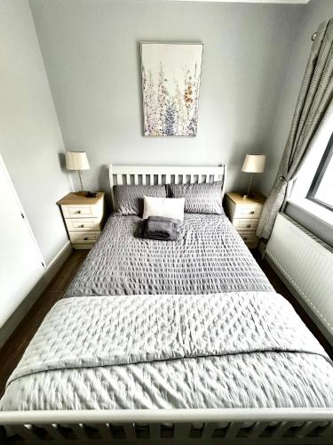 a bedroom with a bed with two night stands and two lamps at The Ocean Nest 