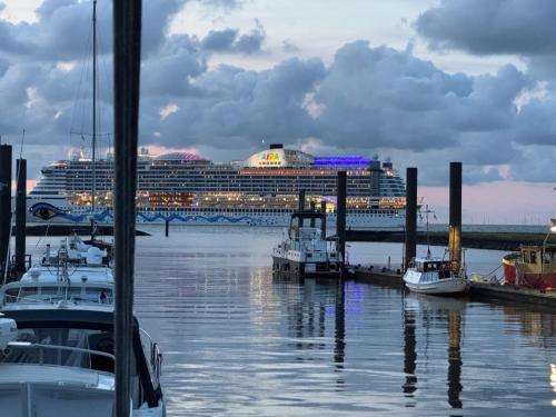 a cruise ship is docked at a dock with boats at Seewolf in Cuxhaven