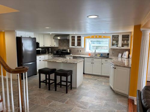 a kitchen with white cabinets and a black refrigerator at Large family house on the lake in Hewitt