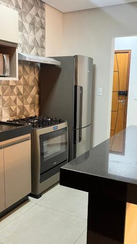 a kitchen with a stainless steel stove and refrigerator at Apartamento Inteiro em Piumhi Conforto no Centro in Piumhi