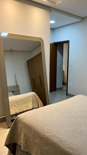 a room with two beds and a mirror on the wall at Apartamento Inteiro em Piumhi Conforto no Centro in Piumhi
