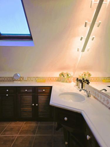 un bagno con un lavandino bianco e una finestra di Quinta de Valverde a Viana do Castelo