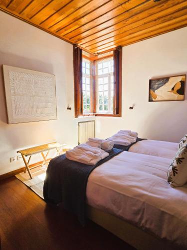 una camera da letto con due letti e un tavolo di Quinta de Valverde a Viana do Castelo