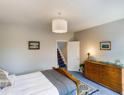 a bedroom with a bed and a dresser and a staircase at 4 Bedroom Belfast Townhouse in Belfast