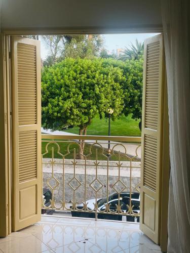 an open door to a balcony with a view of a park at Appartement Mendoubia in Tangier