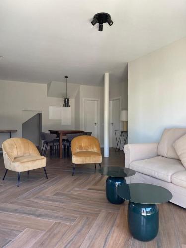 a living room with a couch and a table at Casa com jardim perto da praia in Sesimbra