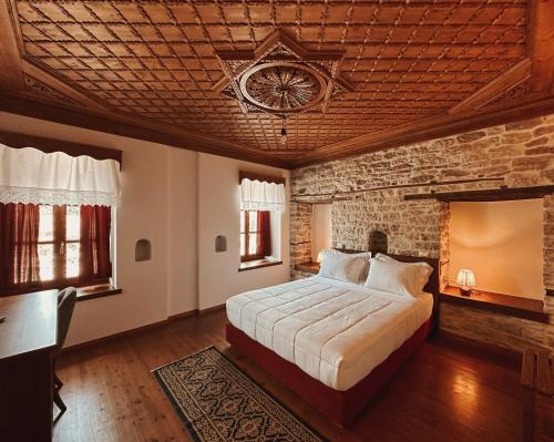 a bedroom with a large bed and a brick wall at Kalemi Twin Boutique Hotel in Gjirokastër