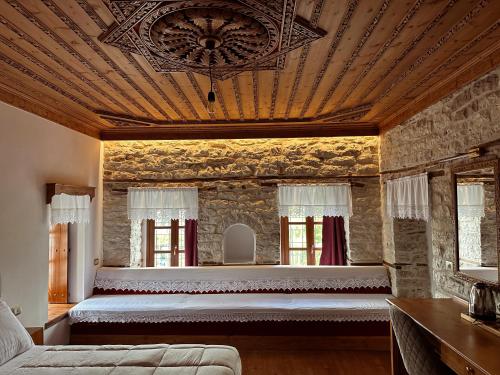 a bedroom with a large bed in a stone wall at Kalemi Twin Boutique Hotel in Gjirokastër