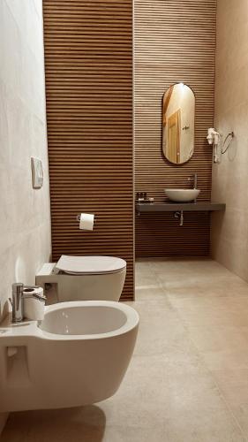 a bathroom with a sink and a toilet and a mirror at Kalemi Twin Boutique Hotel in Gjirokastër
