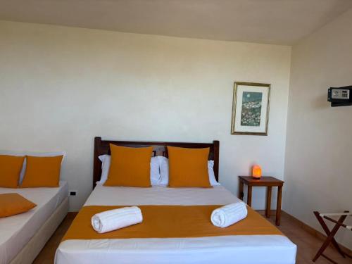 a bedroom with a bed with orange and white pillows at SELINUNTHIA Country House in Marinella di Selinunte