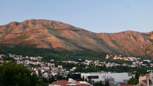 a view of a city with a mountain in the background at Soti Apartments in Kupari