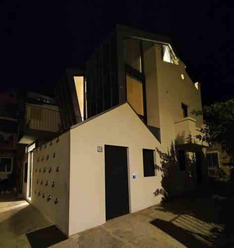 a white building with a door at night at Apartamento Bruño julio y agosto min 7n in Cangas de Morrazo