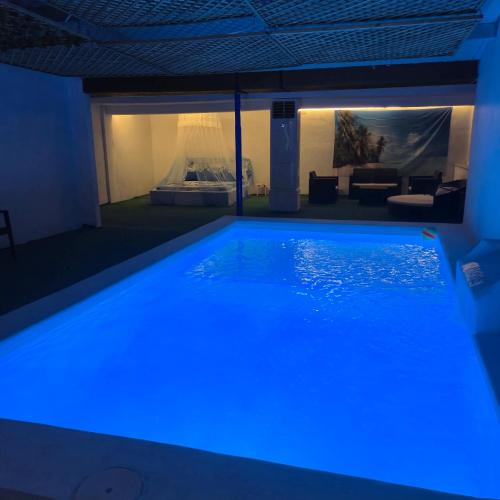 a swimming pool with blue lighting in a living room at Casa Rural Mayne in Villafranca de los Caballeros