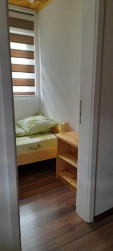 a small bedroom with a bed and a window at Holiday Home Krejović in Žabljak