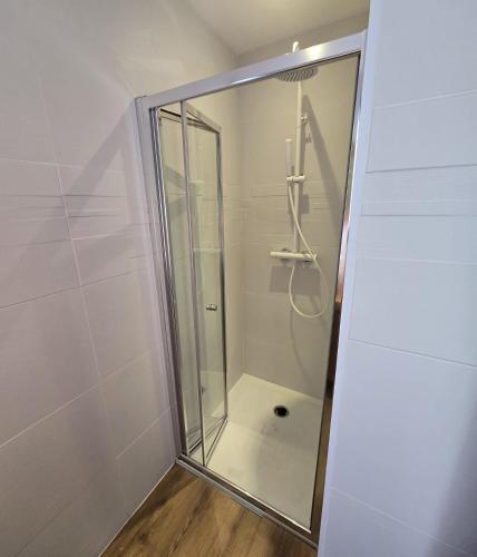 une douche avec une porte vitrée dans une salle de bain dans l'établissement Ubud, à Sainte-Marie-la-Mer