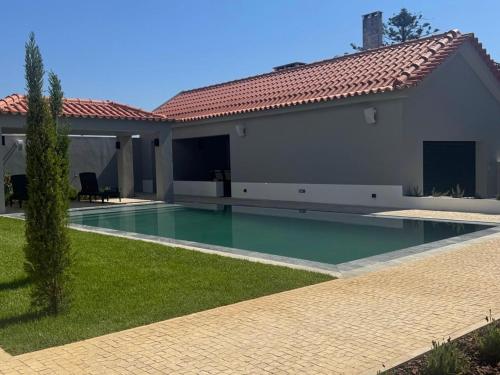 a swimming pool in front of a house at Casa com jardim perto da praia in Sesimbra