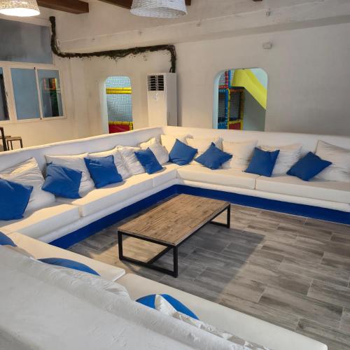 a living room with a white couch with blue pillows at Casa Rural Mayne in Villafranca de los Caballeros