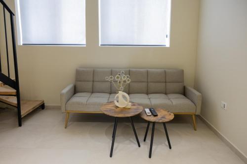 a living room with a couch and two tables at Hana Apart-hotel in Sarandë