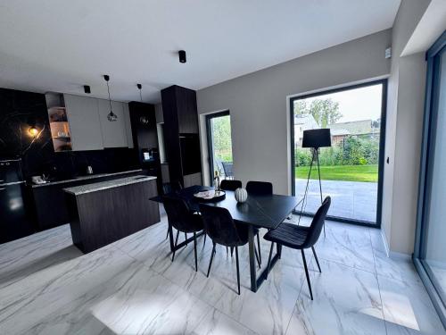een keuken en eetkamer met een zwarte tafel en stoelen bij Marina Dziwnow Premium Haus in Dziwnów