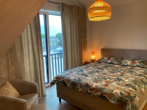 a bedroom with a bed and a window with a balcony at Sunset Apartment in Viljandi