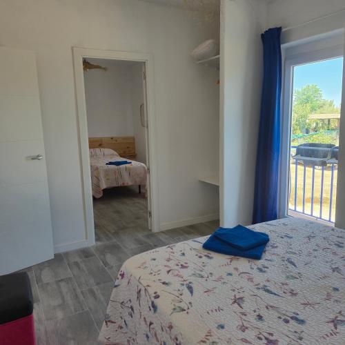 a bedroom with a bed and a door to a balcony at Casa Rural Mayne in Villafranca de los Caballeros