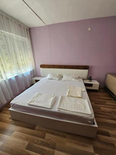 un lit dans une chambre avec un mur violet dans l'établissement Prizren Nest, à Prizren