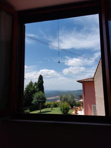 a window looking out at a view of a yard at Il Fienile in Casole dʼElsa