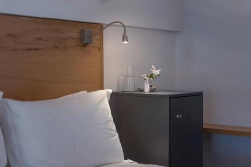 a bed with a white pillow and a lamp on a table at Arch Window garden apartment in Stellenbosch